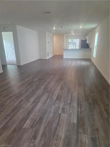 Unfurnished living room featuring dark wood finished floors