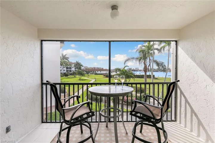 Sunroom / solarium with a water view and golf course view