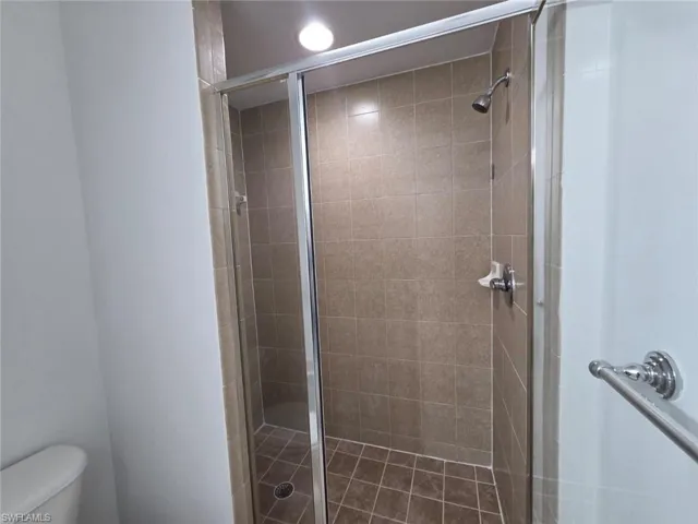 Bathroom featuring toilet and a stall shower