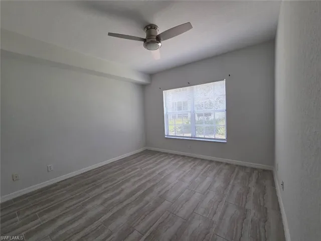 Empty room with wood finish floors and ceiling fan