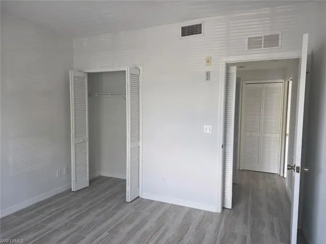 Unfurnished bedroom with a closet and wood tiled floors