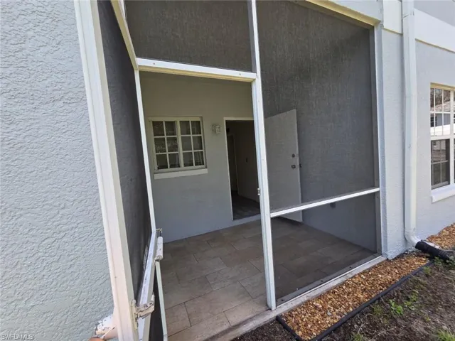 Doorway to property featuring stucco siding