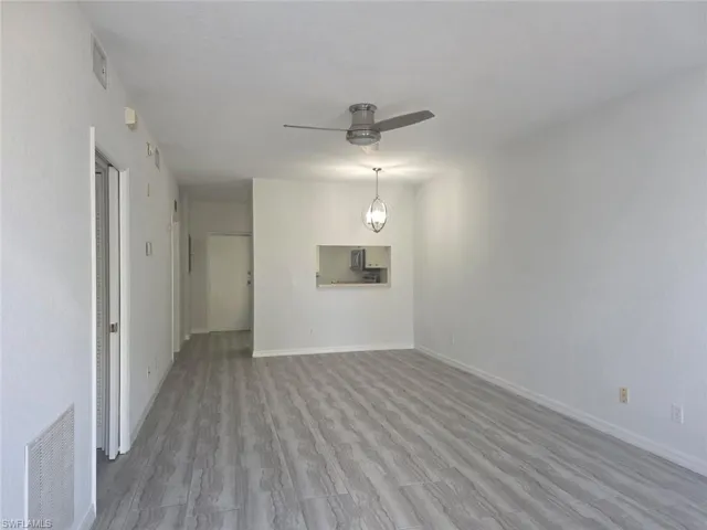Unfurnished living room with wood finished floors and ceiling fan