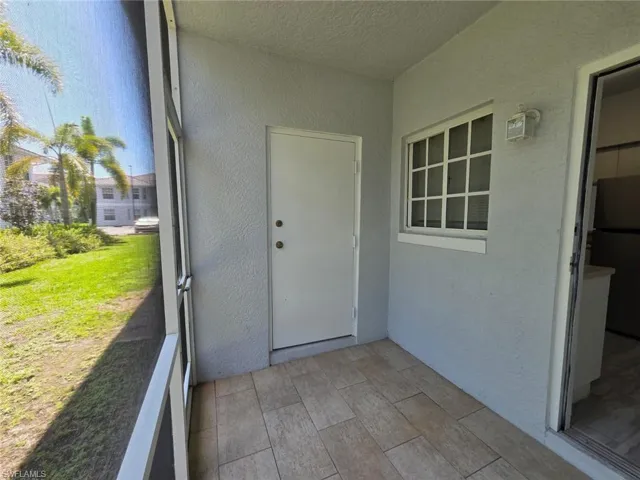 Property entrance featuring a sunroom and stucco siding