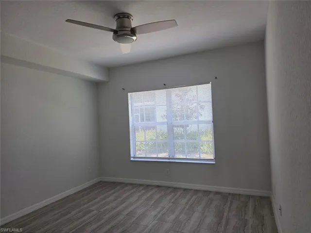 Empty room with wood finished floors and ceiling fan