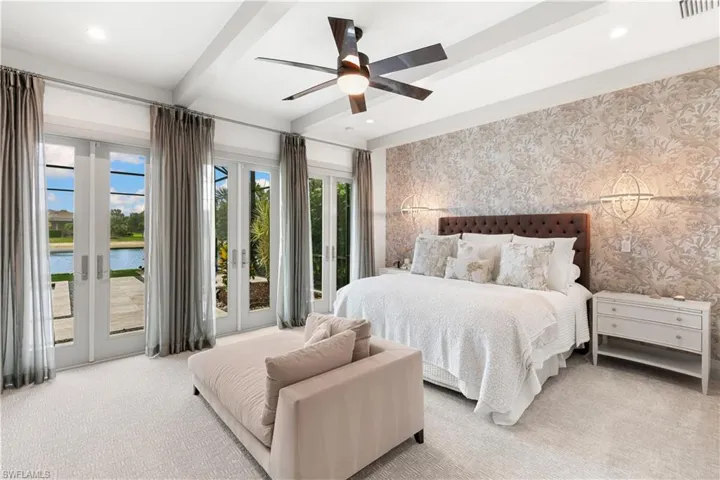 Dramatic and luxurious primary with 3 sets of French doors out to the pool.