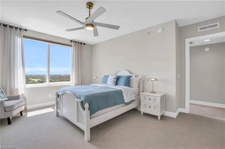 Carpeted bedroom featuring ceiling fan