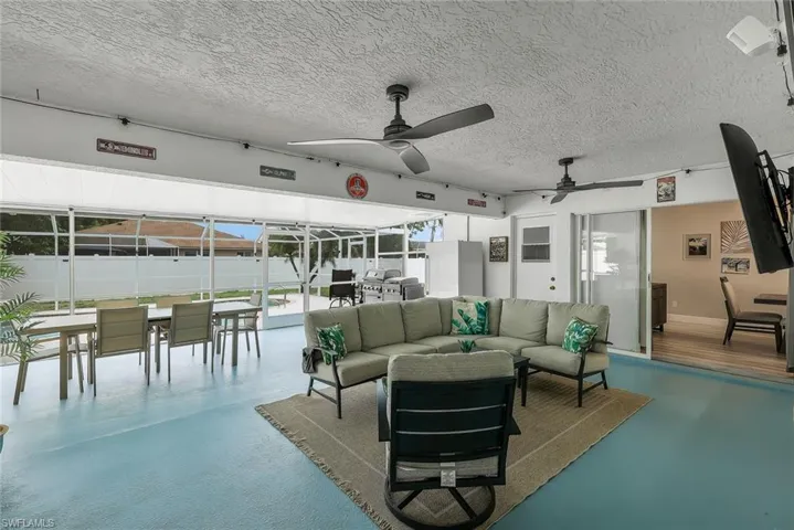 Screened outdoor living area featuring a light blue flooring finish and a textured ceiling