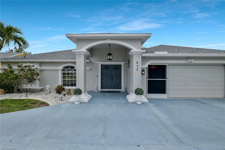 Stucco exterior with a covered entry, arched portico, and double entry doors