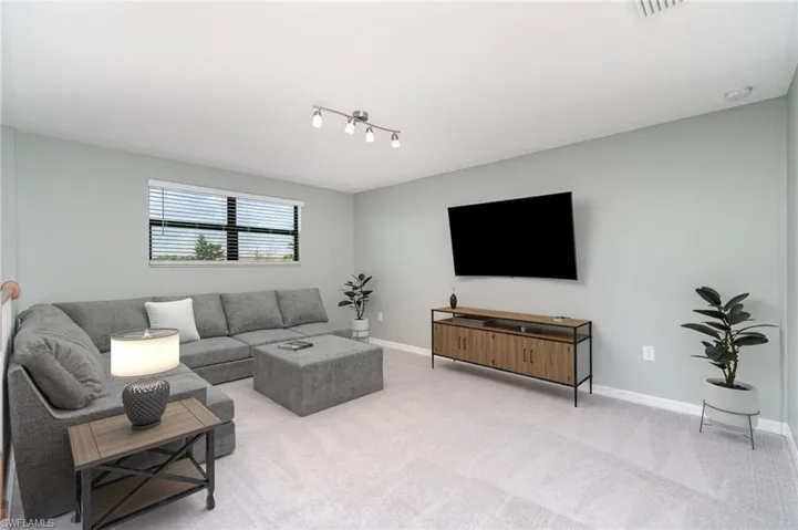 Carpeted living area with baseboards