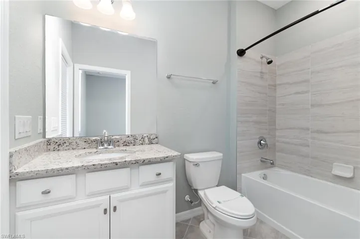 Full bathroom with shower / bath combination, vanity, and light tile patterned floors