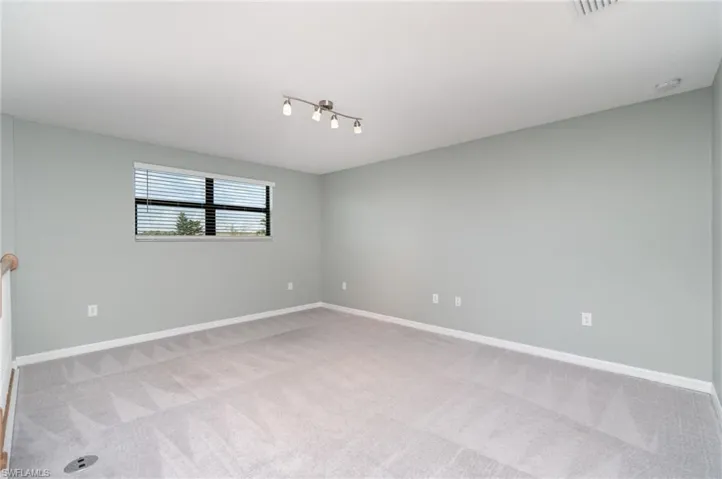 Unfurnished room with light colored carpet and baseboards