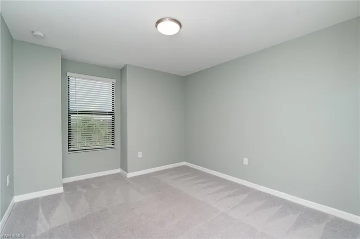 Spare room with light colored carpet and baseboards