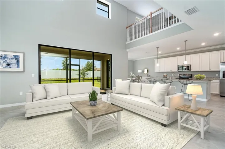 Living room featuring a high ceiling, plenty of natural light, recessed lighting, and ornamental molding