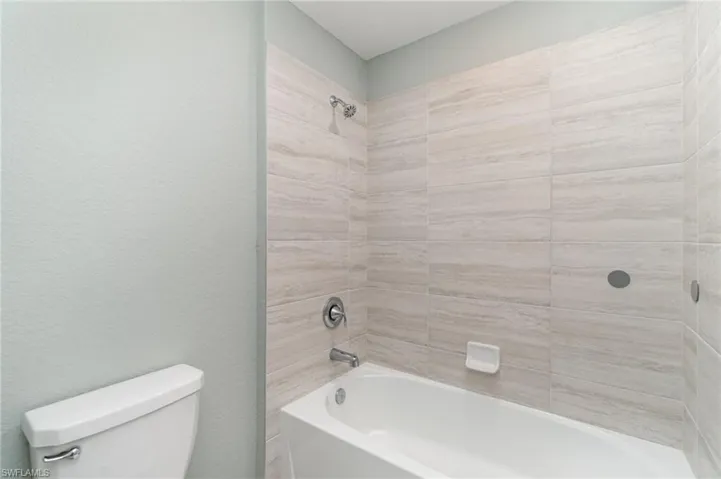 Full bathroom featuring shower / washtub combination and a textured wall