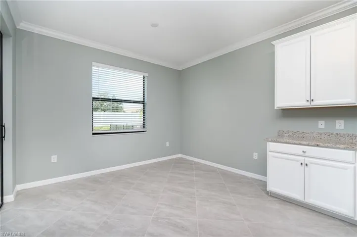 Unfurnished dining area with crown molding and light tile patterned floors