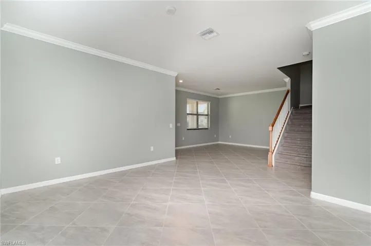 Empty room with ornamental molding, stairs, light tile patterned flooring, and recessed lighting
