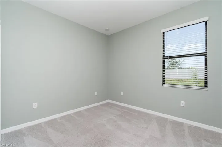 Unfurnished room featuring light colored carpet and baseboards