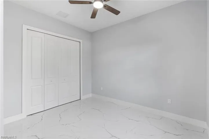 Room featuring wood-finish ceiling fan, light gray wall paint, and white baseboards