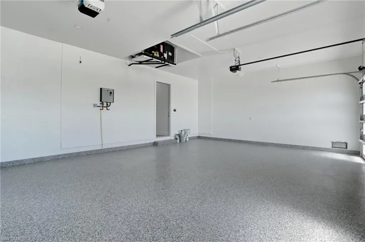 Garage featuring a garage door opener and baseboards