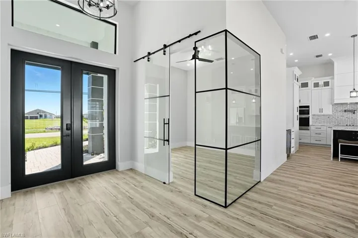Entryway with wood finished floors, french doors, healthy amount of natural light, and recessed lighting
