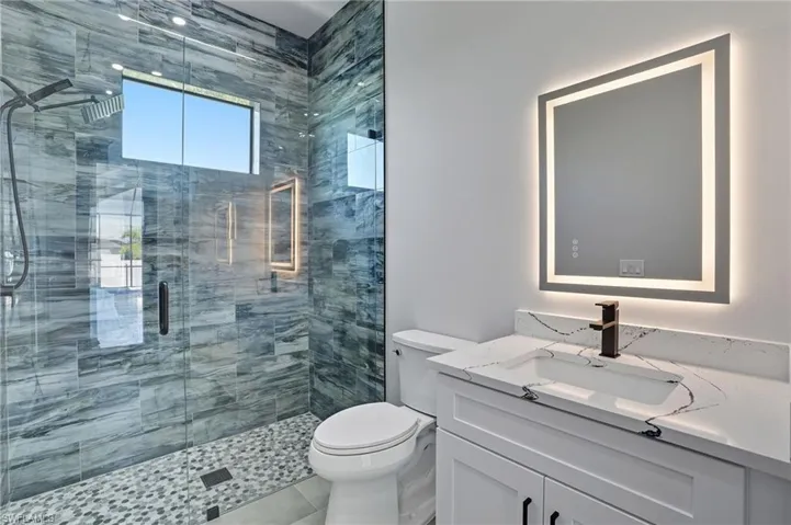 Bathroom featuring a shower stall and vanity