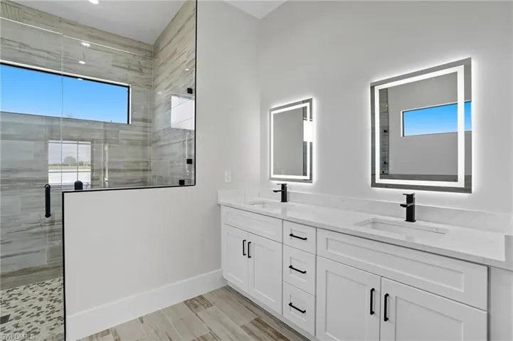 Full bathroom with a shower stall, double vanity, and wood tiled floors