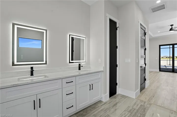 Bathroom with double vanity, recessed lighting, and light wood-type flooring