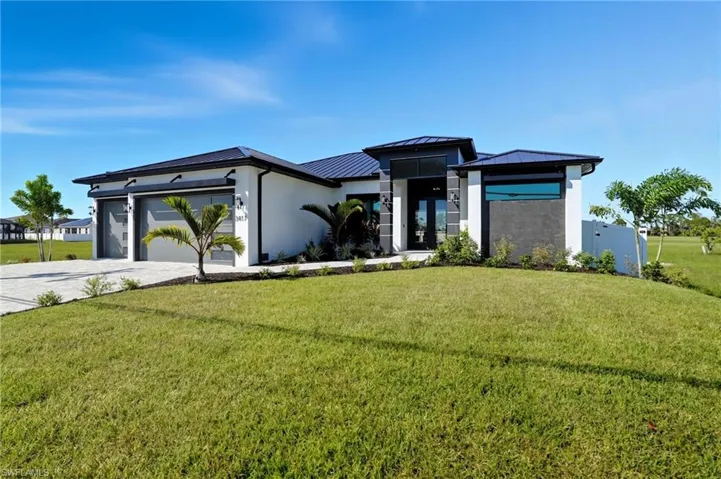 Prairie-style home with stucco siding, a standing seam roof, a metal roof, a garage, and driveway