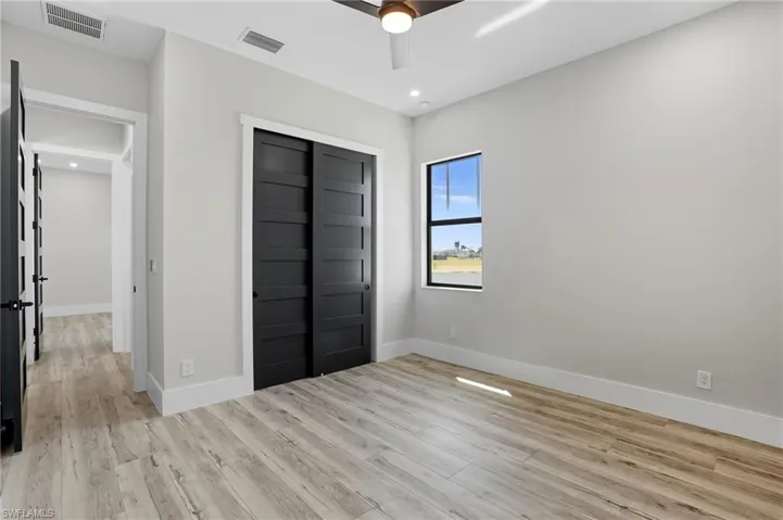 Unfurnished bedroom with light wood-style flooring, a closet, a ceiling fan, and recessed lighting