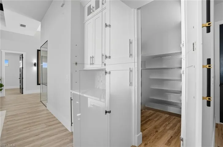 Corridor featuring light wood finished floors and baseboards