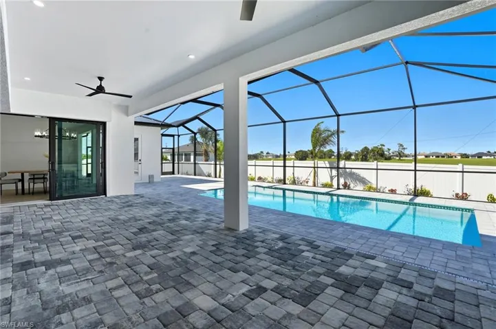 View of pool featuring a ceiling fan, a patio, a sunroom, and glass enclosure