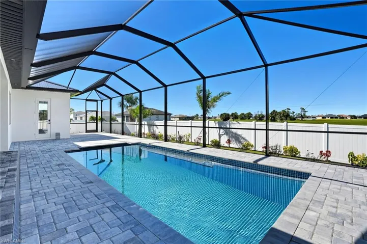 View of swimming pool featuring a sunroom, a patio, and glass enclosure