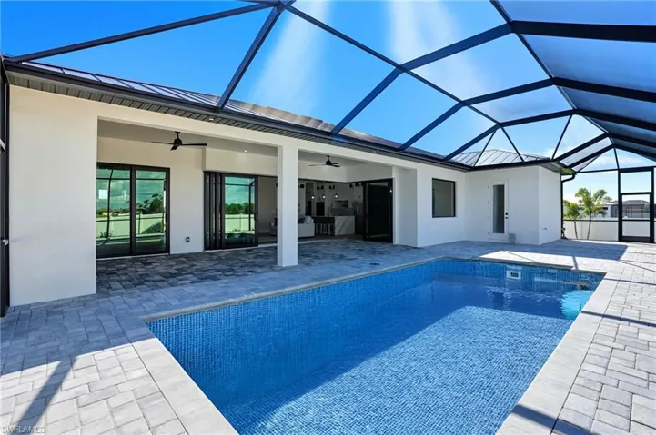 Swimming pool featuring a sunroom, glass enclosure, a patio, and a ceiling fan