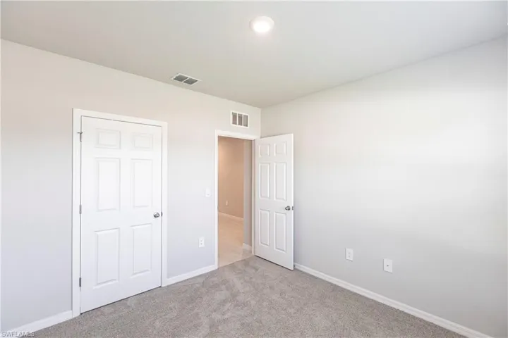 Unfurnished bedroom featuring a closet and light carpet