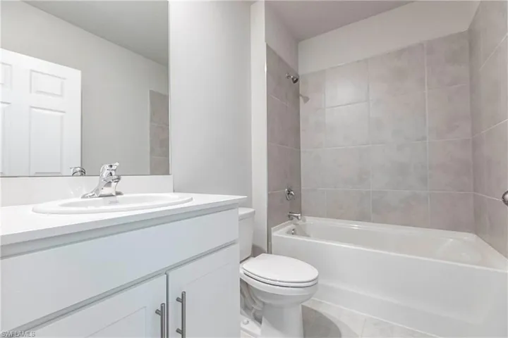Full bathroom with tile patterned flooring, vanity, toilet, and tiled shower / bath