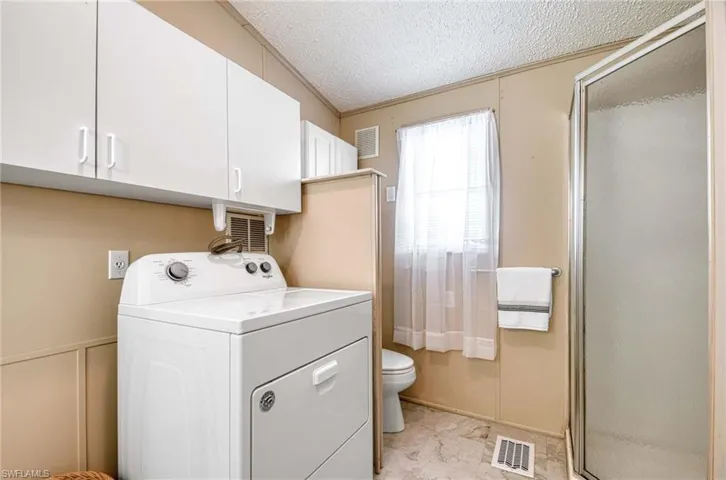 Laundry area with a textured ceiling and washer / clothes dryer