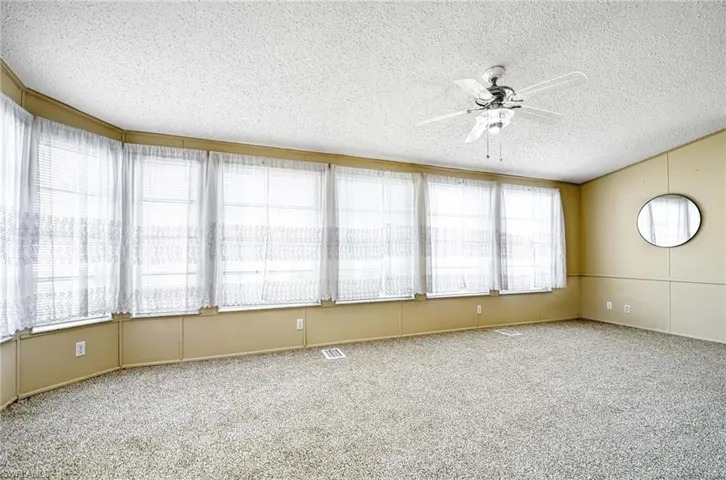 Unfurnished sunroom featuring a wealth of natural light and ceiling fan