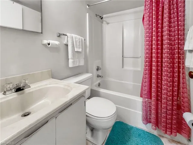 Full bathroom with shower / bath combo with shower curtain, toilet, and vanity