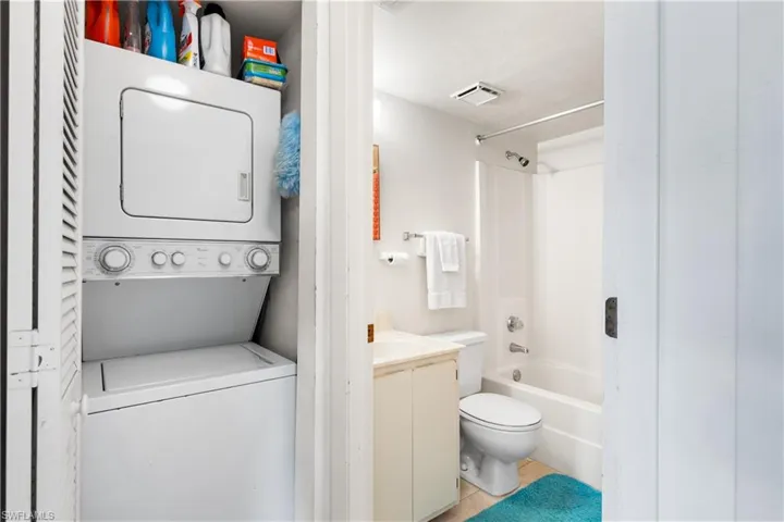 Full bathroom with tub / shower combination, stacked washing maching and dryer