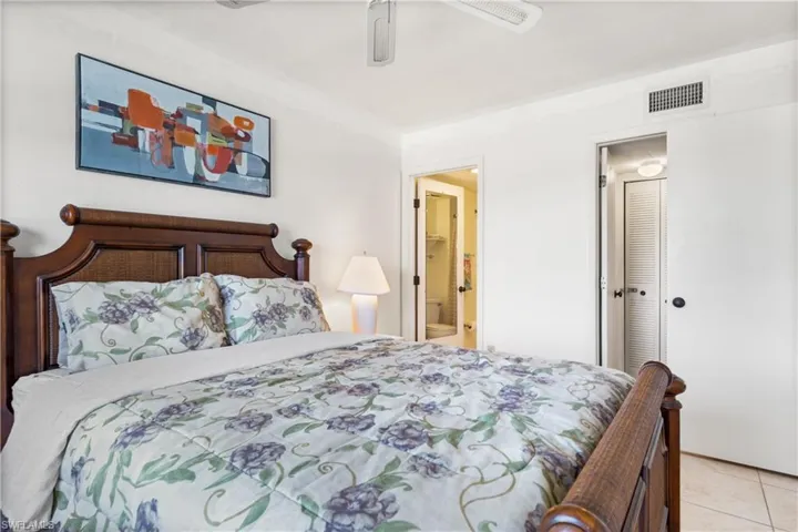Tiled bedroom featuring connected bathroom, and closet