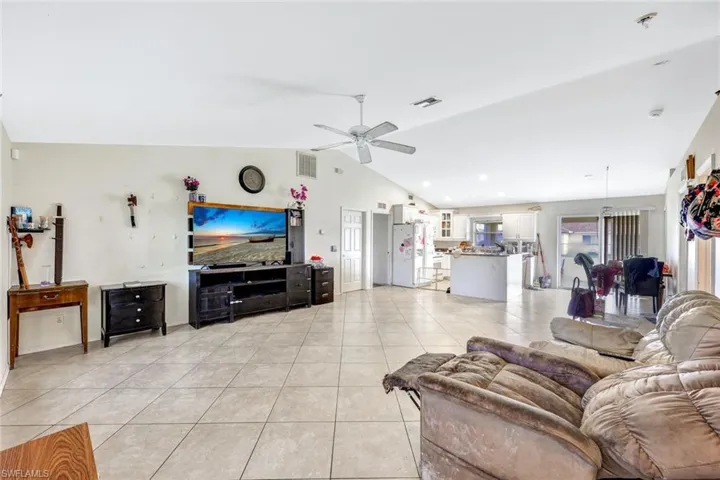Tiled living room featuring vaulted ceiling and ceiling fan