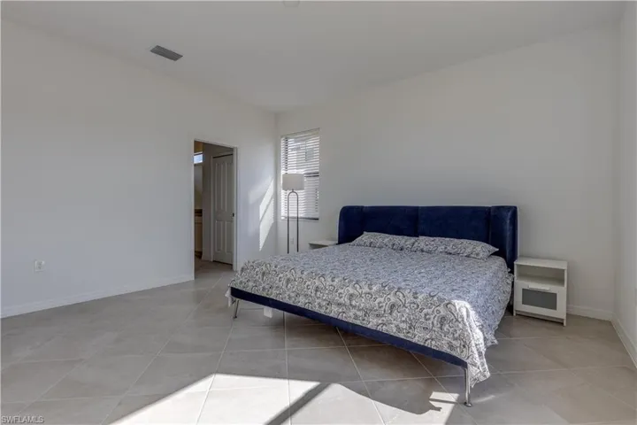 Bedroom with baseboards and light tile patterned flooring
