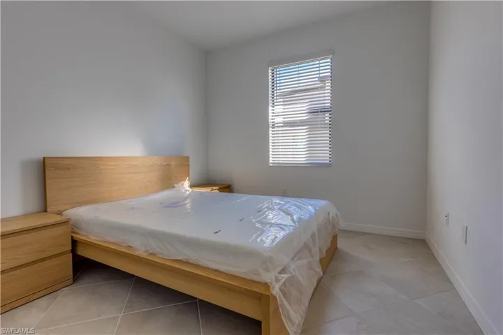 Bedroom featuring light tile patterned floors and baseboards