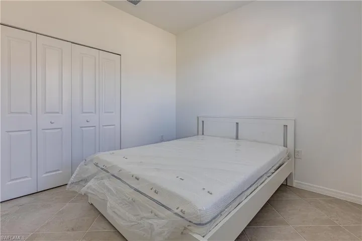 Bedroom featuring a closet and light tile patterned floors