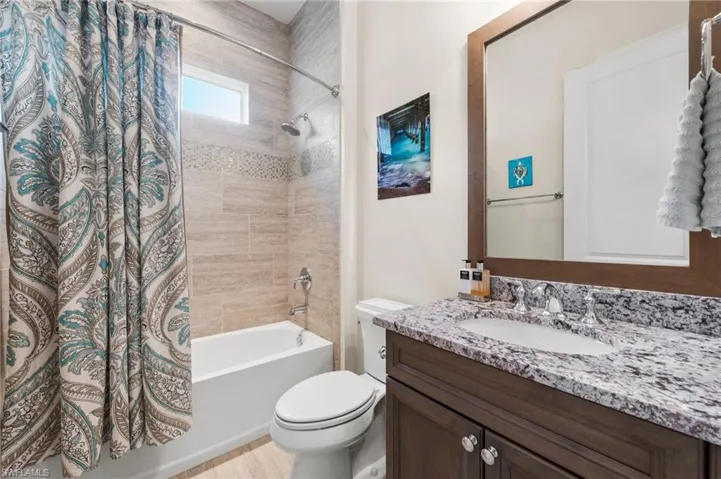 Full bathroom featuring vanity, toilet, and shower / bath combo with shower curtain