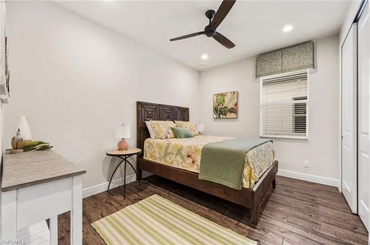 Bedroom featuring dark hardwood / wood-style floors, ceiling fan, and a closet