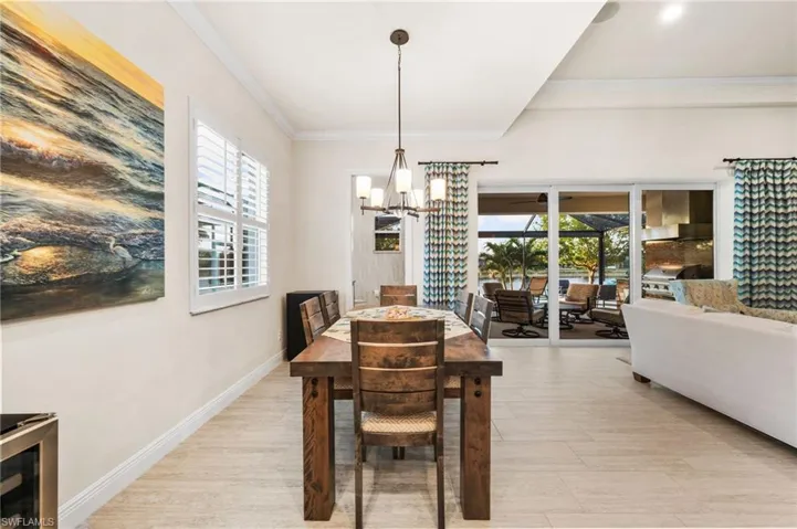 Dining area featuring ornamental molding, a notable chandelier, and light hardwood / wood-style floors