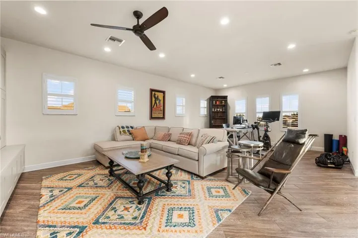 Living room with ceiling fan and light hardwood / wood-style flooring