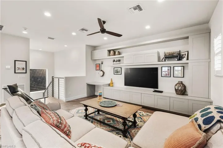 Living room with ceiling fan and light wood-type flooring